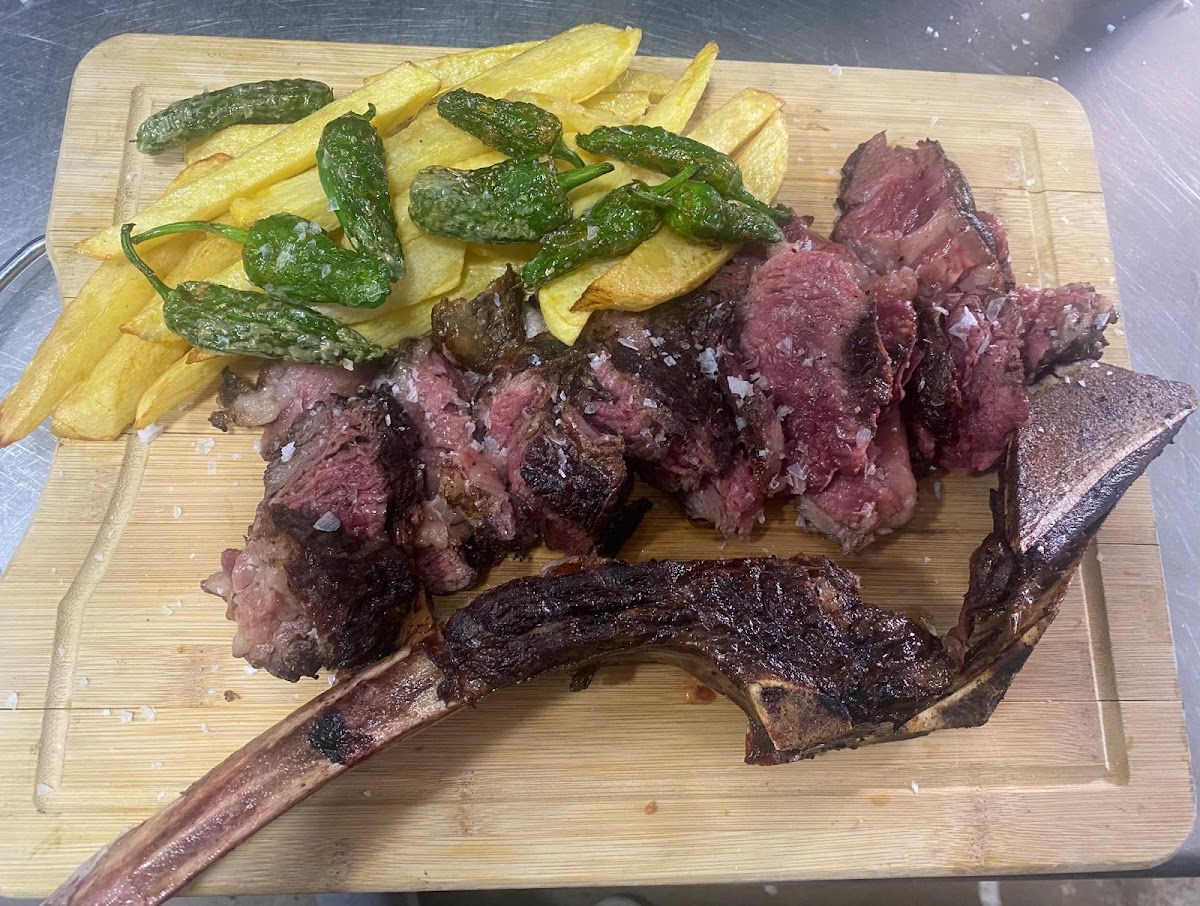 Costilla de ternera asada con patatas fritas y pimientos verdes